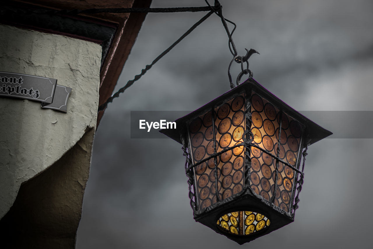 Low angle view of illuminated lanterns hanging by building