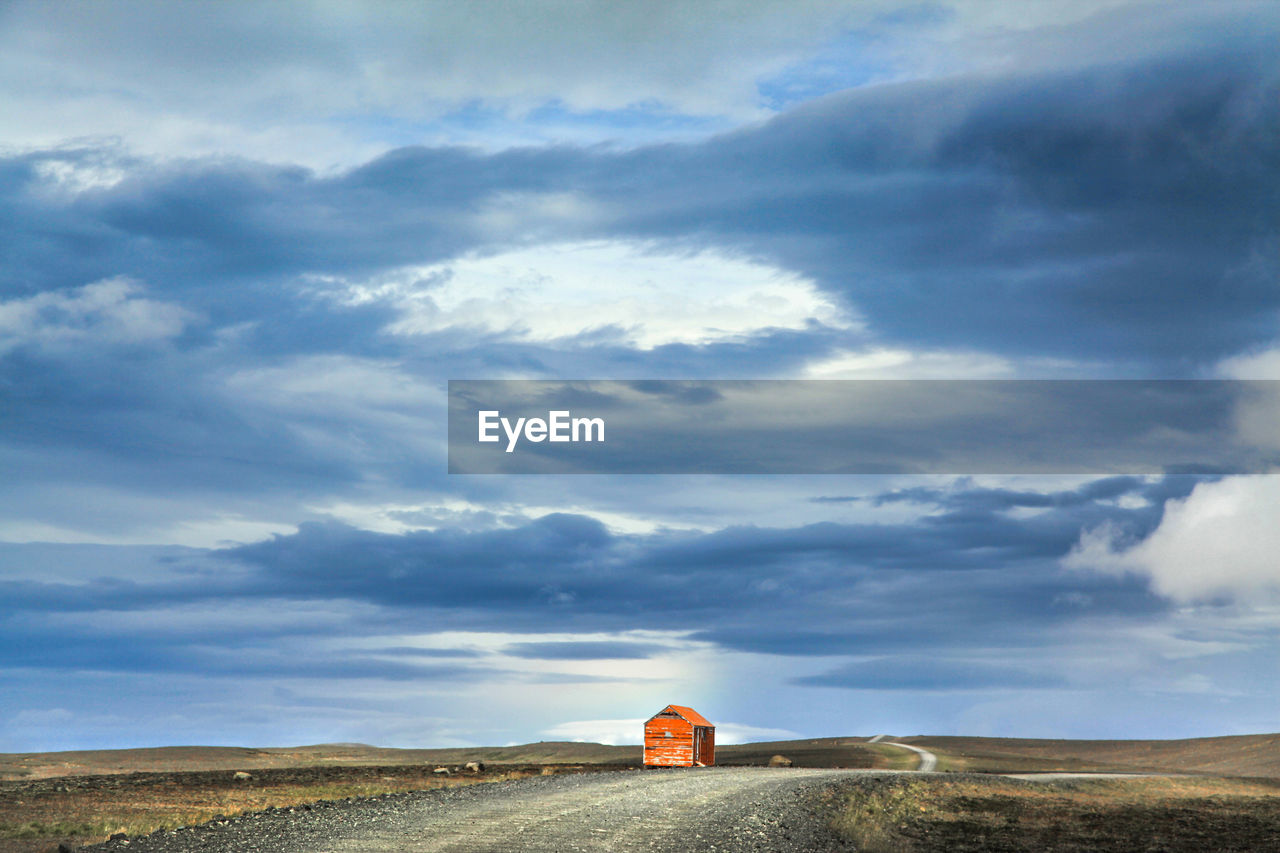 Abandoned hut against cloudy sky
