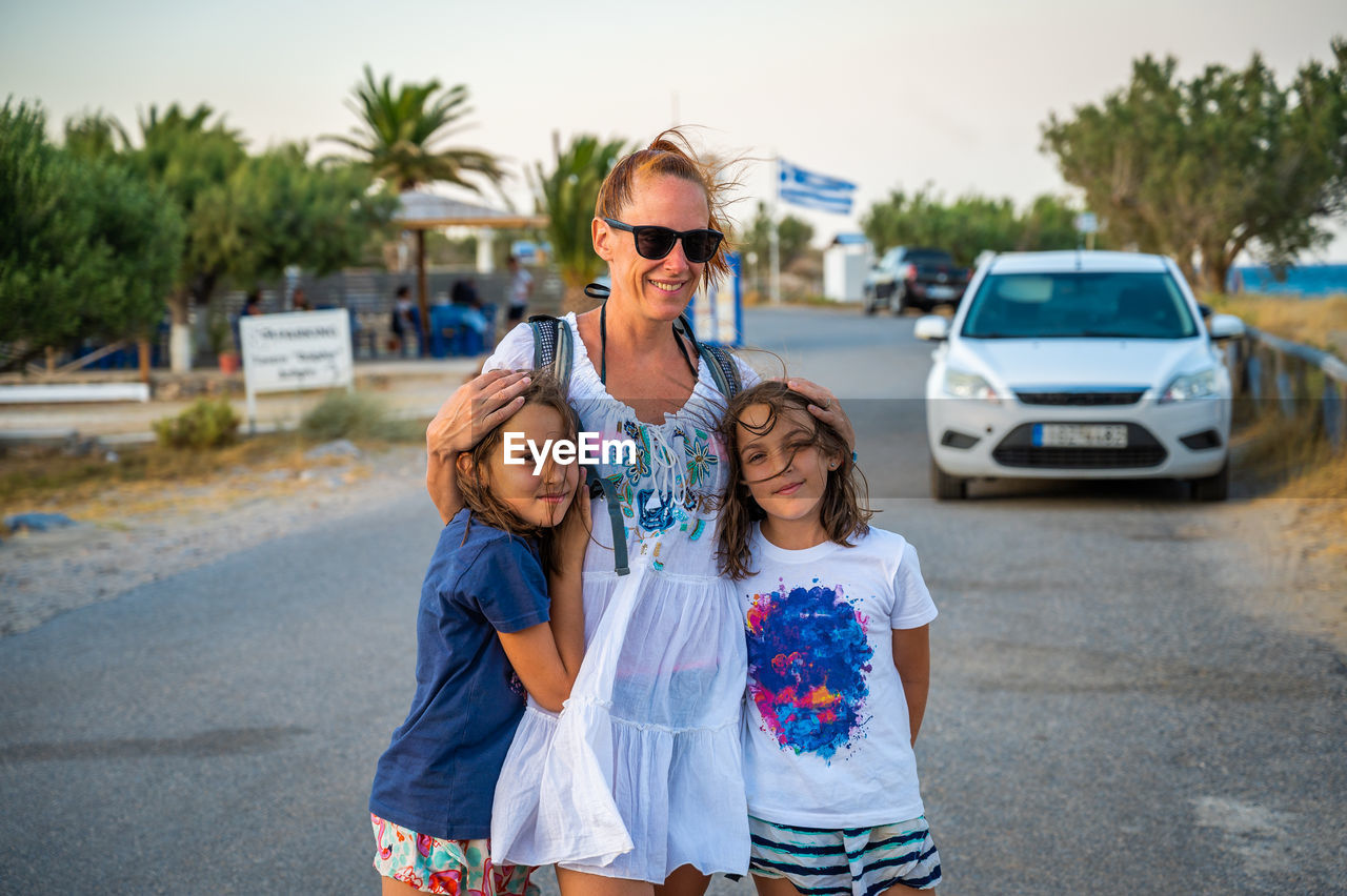 portrait of young woman wearing sunglasses while standing on road