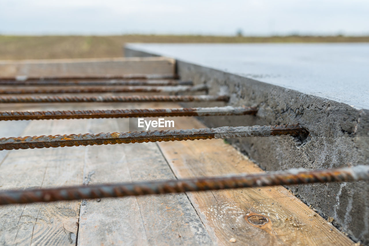 CLOSE-UP OF METAL FENCE ON FIELD