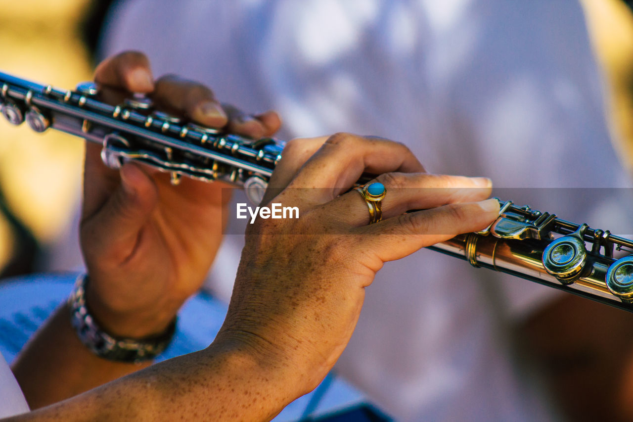 MIDSECTION OF MAN PLAYING GUITAR AT MUSIC CONCERT