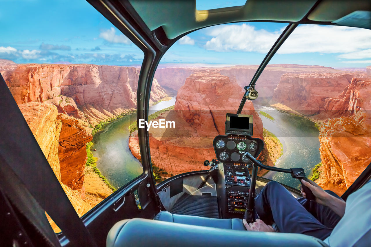 Midsection of man flying helicopter against horseshoe bend