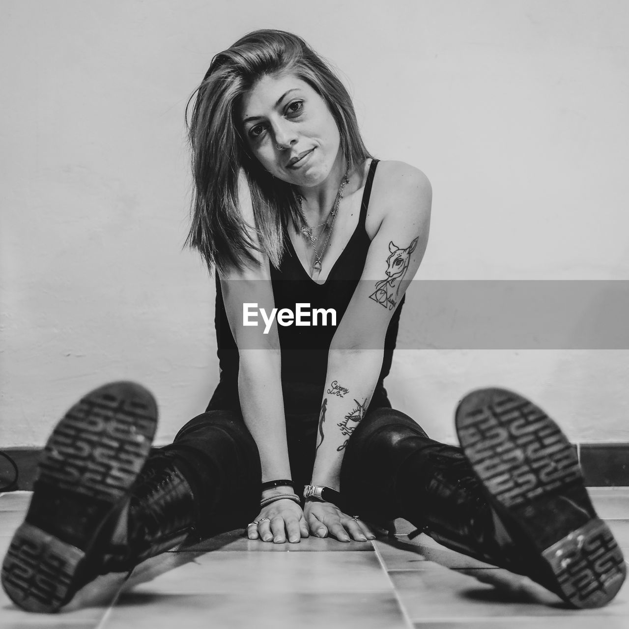 sitting, one person, black, adult, women, black and white, footwear, young adult, portrait, white, monochrome, monochrome photography, indoors, long hair, photo shoot, hairstyle, lifestyles, limb, looking at camera, person, full length, shoe, human leg, female, fashion, front view, clothing, casual clothing, arts culture and entertainment, leisure activity, studio shot
