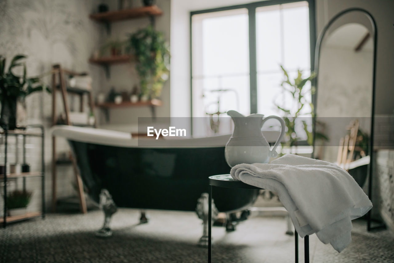 Luxury interior of big bathroom at modern african style with oval bathtub in natural lighting