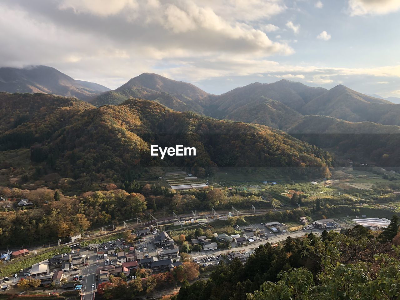 Aerial view of townscape by mountains against sky