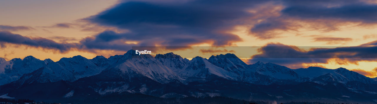 Scenic view of snowcapped mountains against sky during sunset