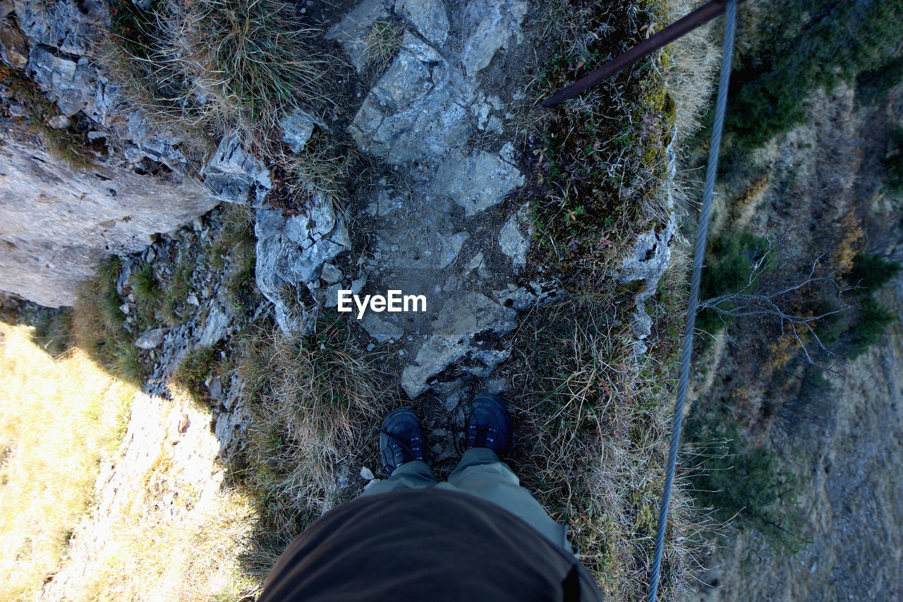 LOW SECTION OF PERSON STANDING ON ROCKS