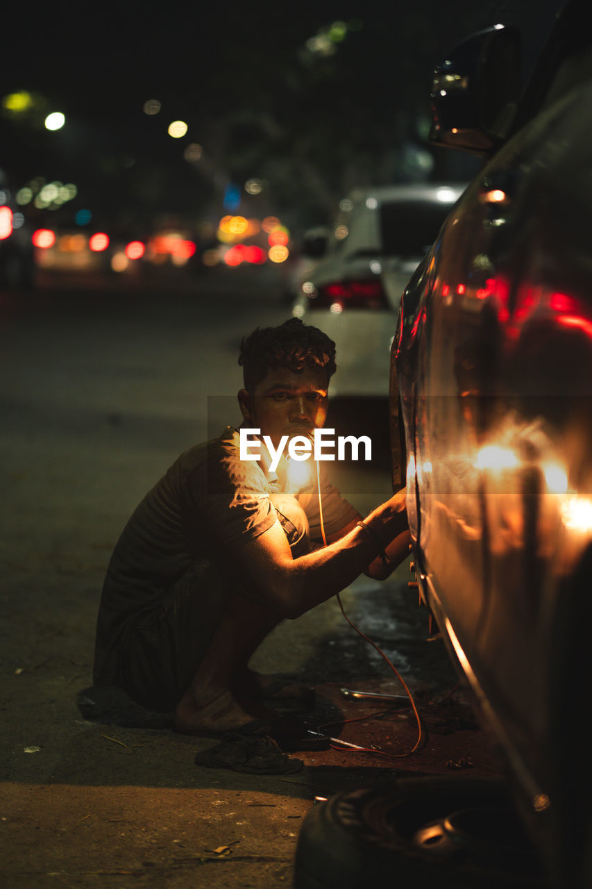 Car mechanic working at night