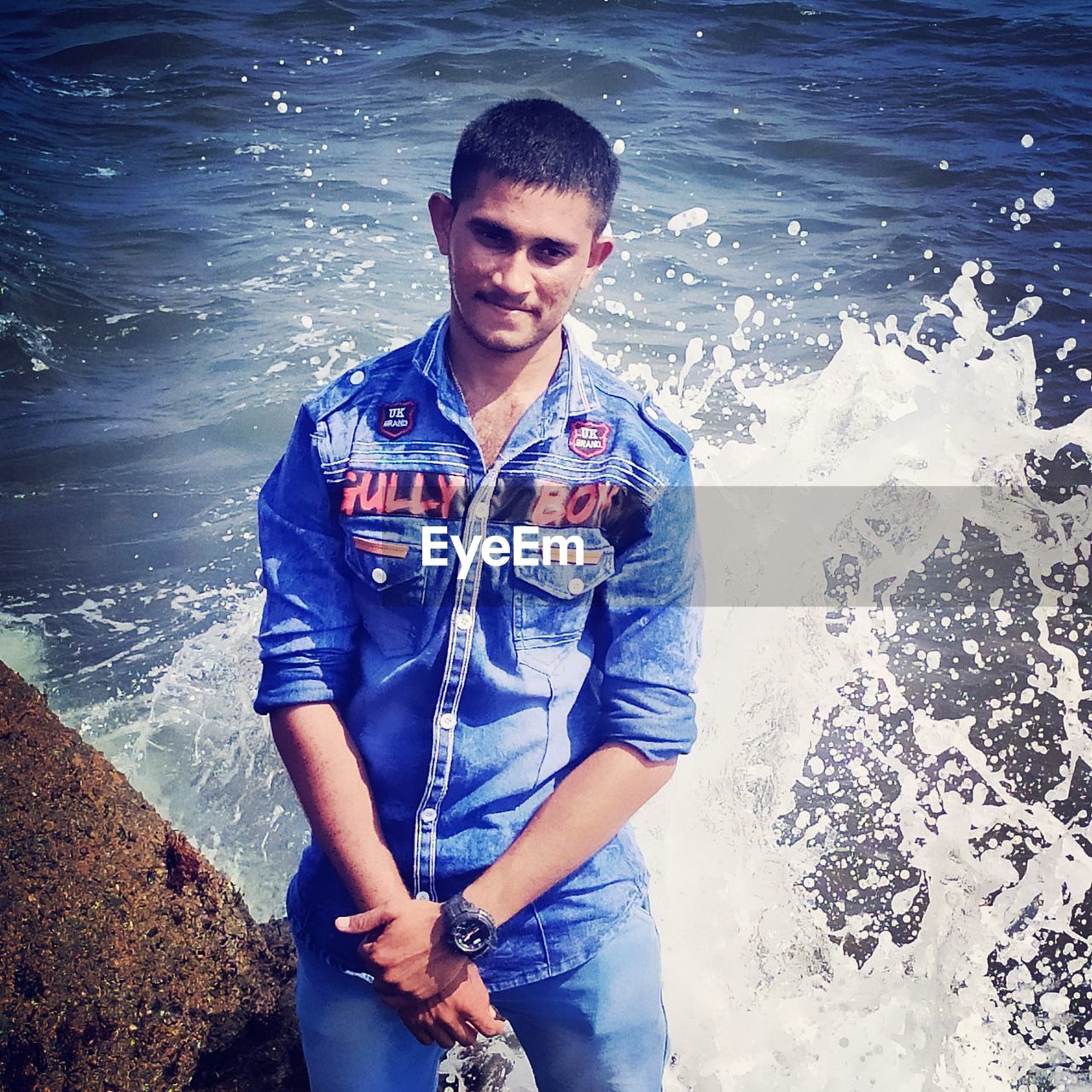 PORTRAIT OF SMILING YOUNG MAN STANDING IN SEA