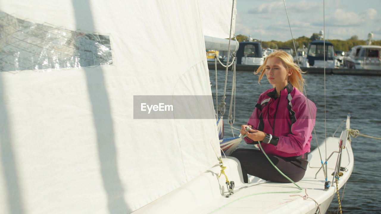 Young woman sitting on boat in water