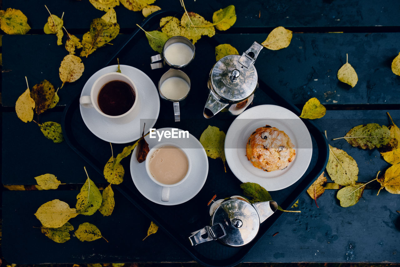High angle view of autumn leaves by breakfast in tray on table