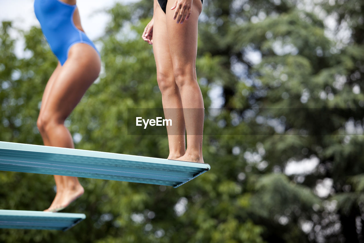Low section of man jumping over diving board