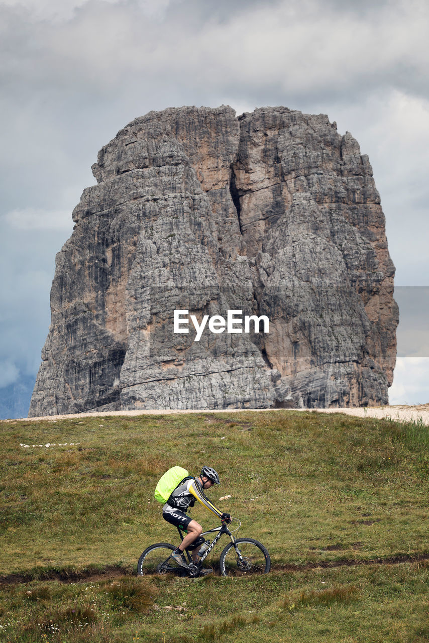 WOMAN RIDING BICYCLE ON ROCK