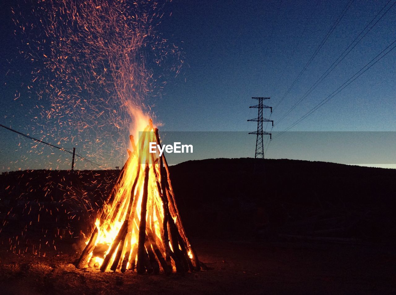 Fire on field against sky at night