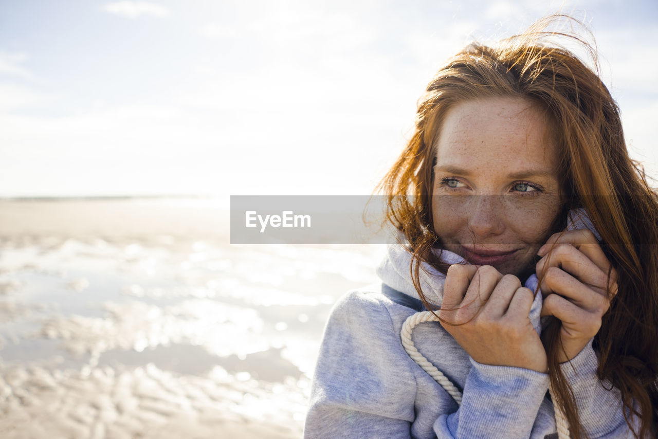 Redheaded woman enjoying fresh air at the beach