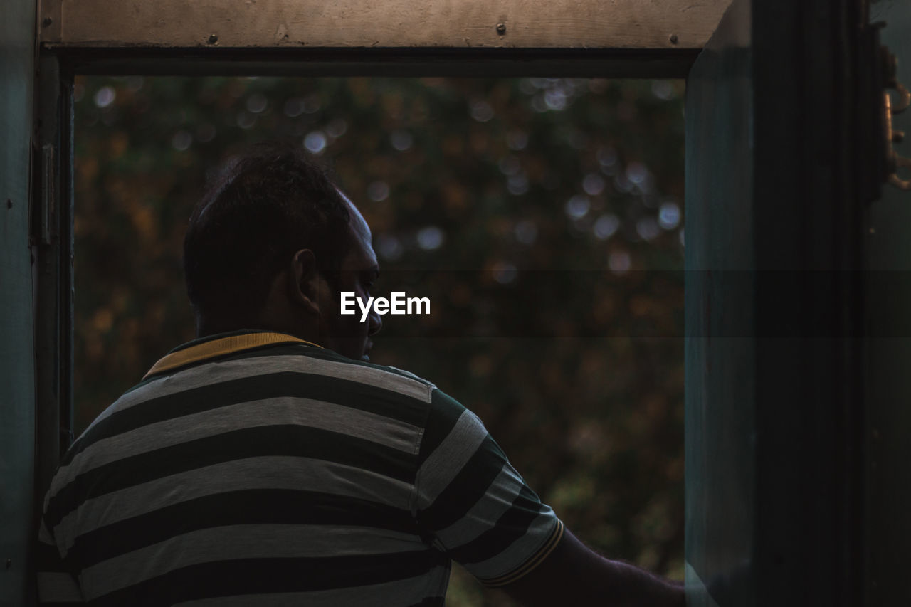 Man looking through window