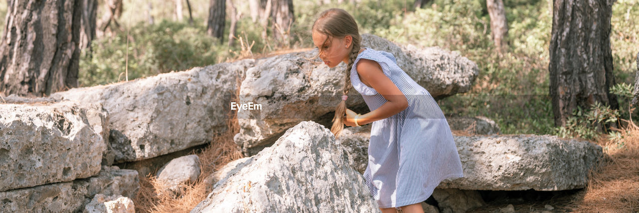 Kid girl traveler of eight years old travel and explore the ancient excavations of the ruins