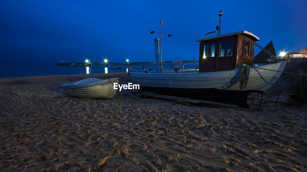 BOATS MOORED ON SHORE AGAINST CLEAR SKY