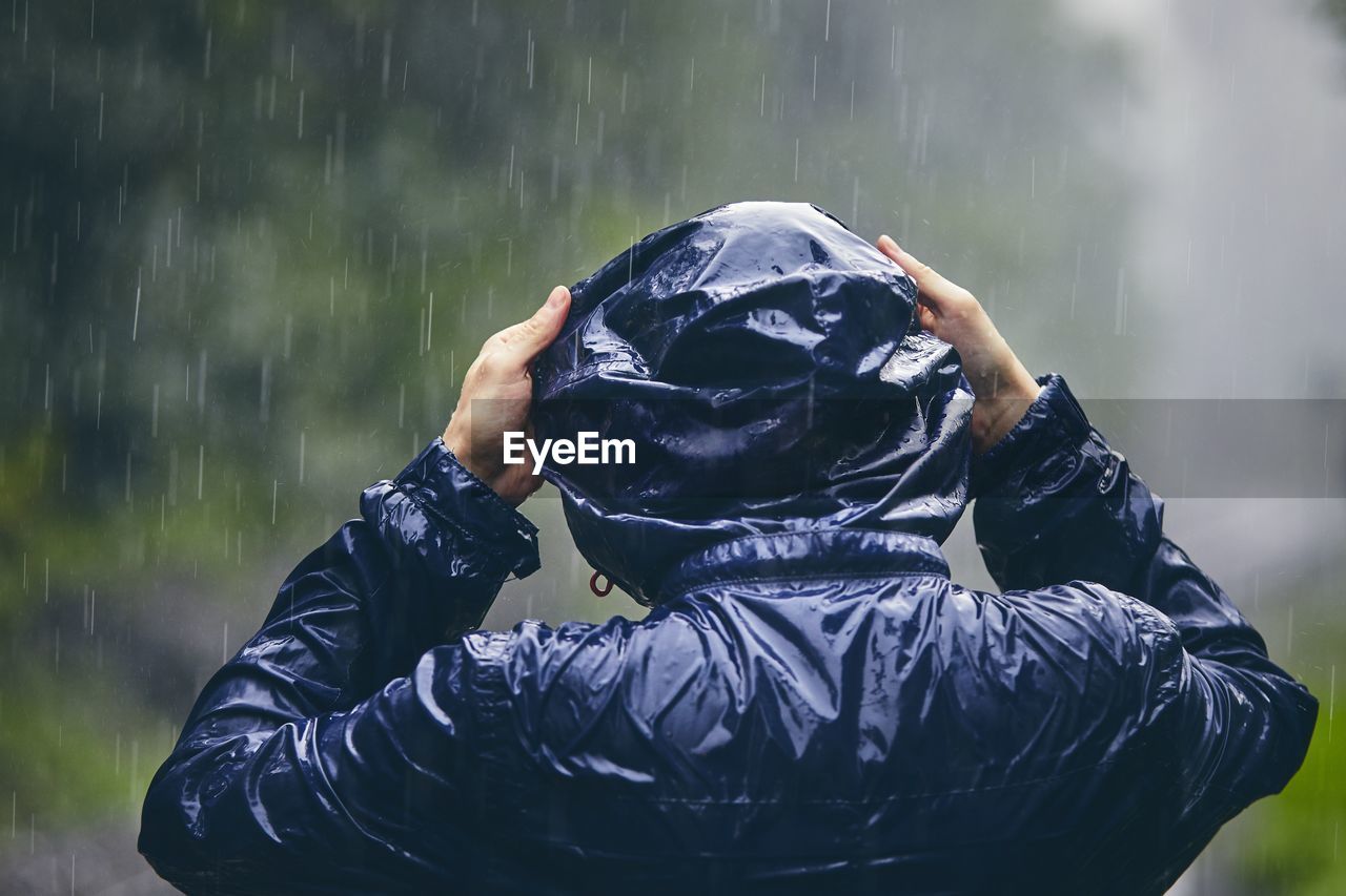 Rear view of man wearing raincoat outdoors