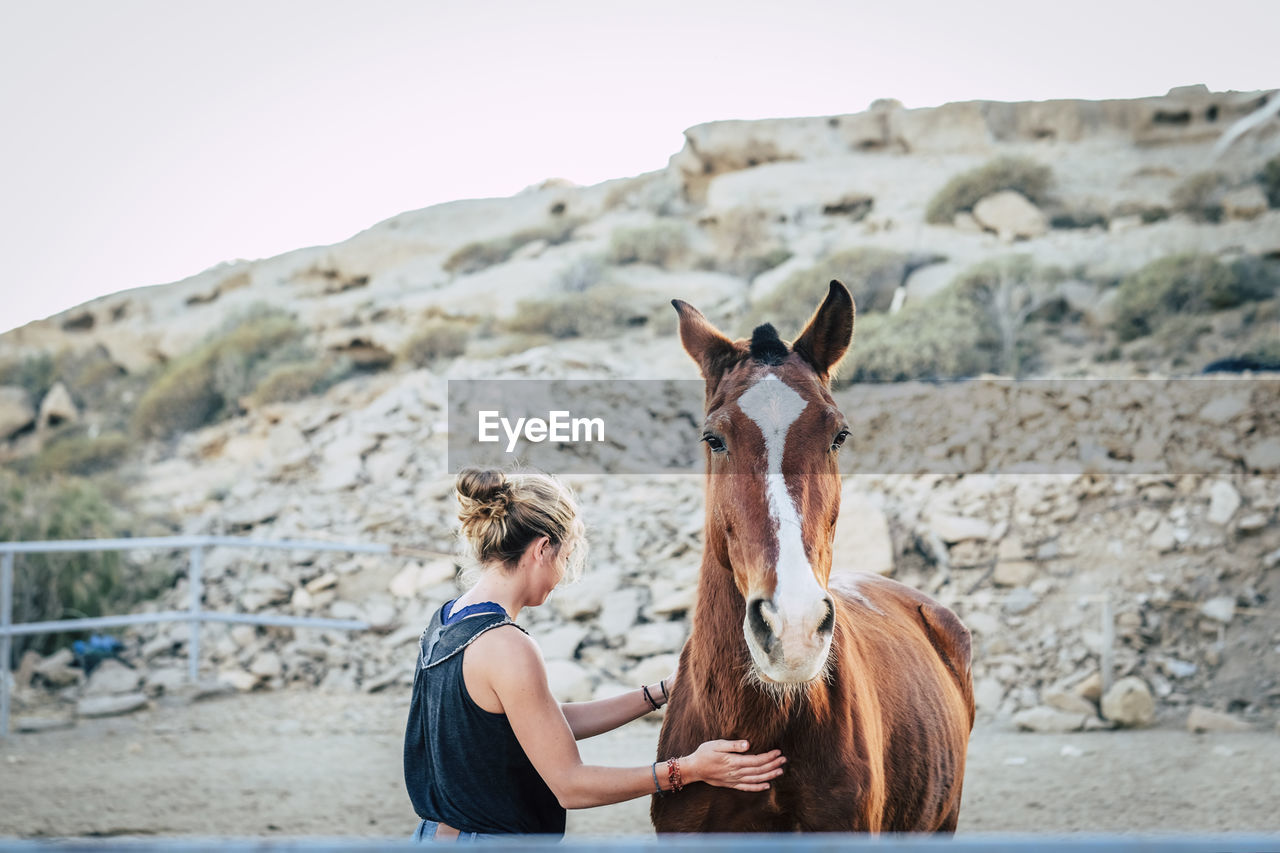 Woman by horse on ground