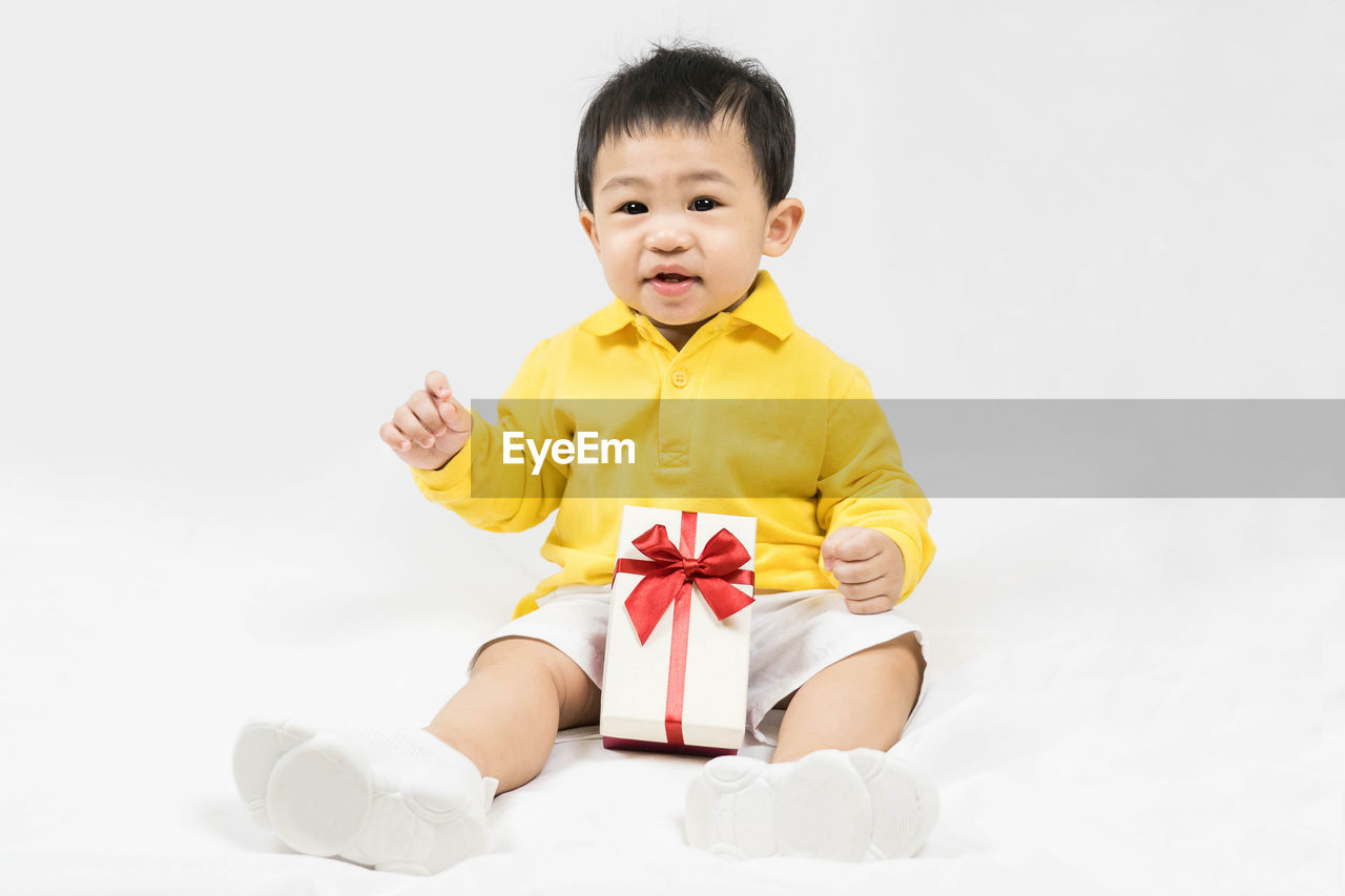 portrait of cute girl sitting on white background