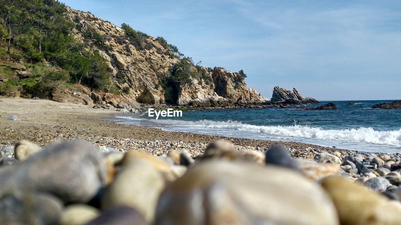 Surface level of pebble beach against sky