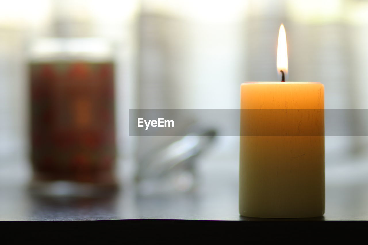 CLOSE-UP OF TEA LIGHT CANDLE ON TABLE