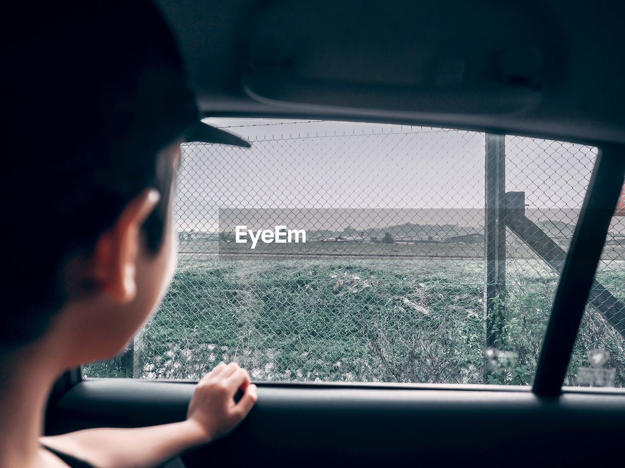 Boy looking through car window