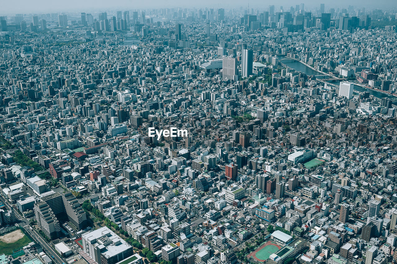 HIGH ANGLE VIEW OF ILLUMINATED CITY BUILDINGS IN BACKGROUND