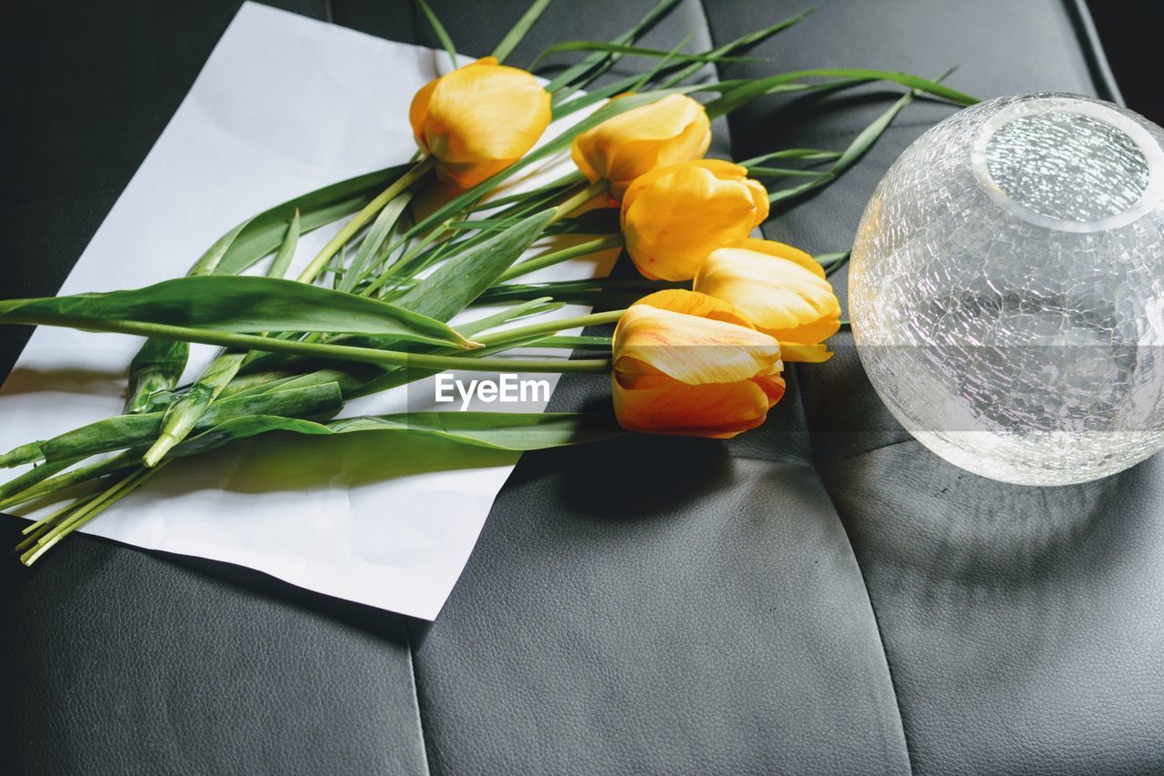 High angle view of tulips by glass container on table