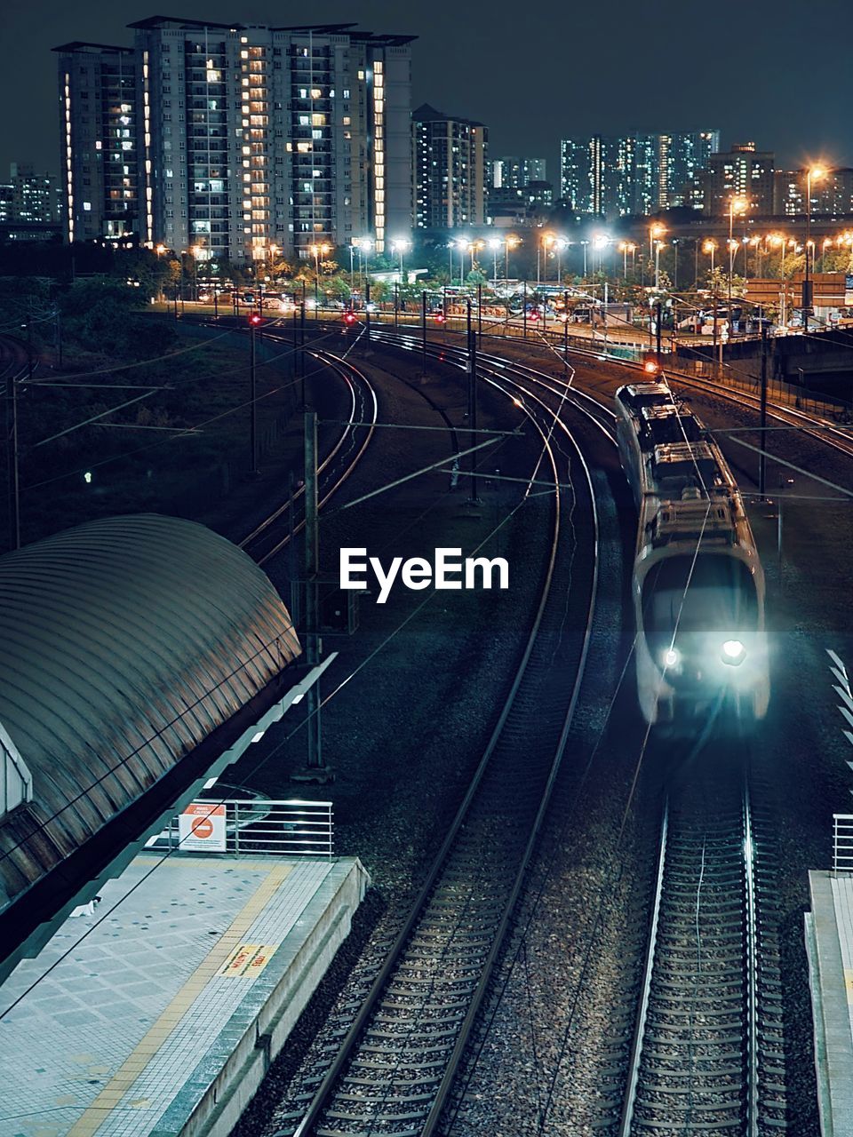 City lights shines on the erl train arriving at the bandar tasek selatan transit station near tbs