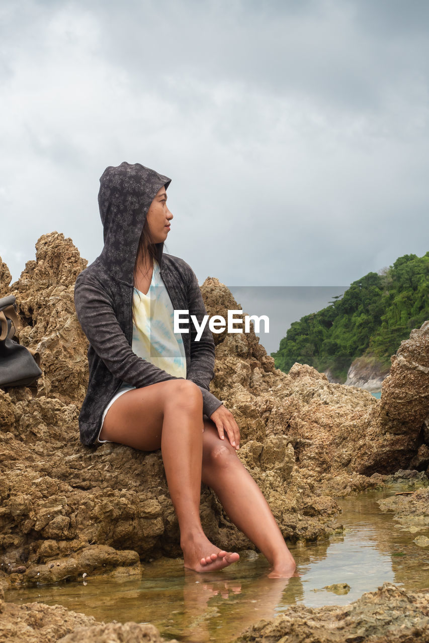 WOMAN SITTING ON ROCK