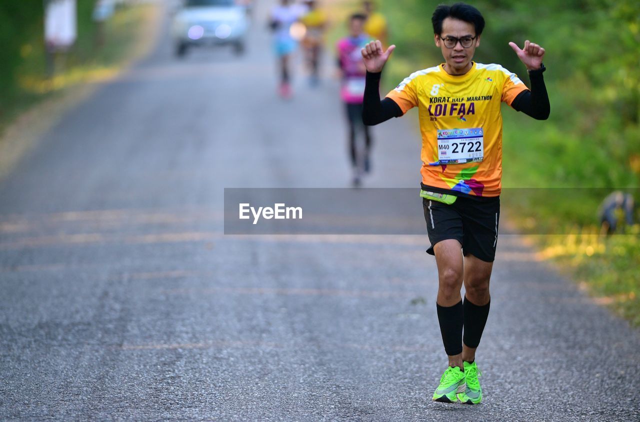 YOUNG MAN RUNNING ON ROAD