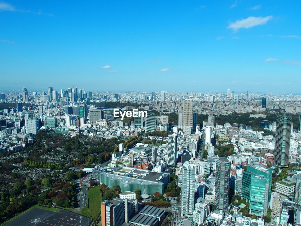 HIGH ANGLE VIEW OF BUILDINGS AGAINST BLUE SKY