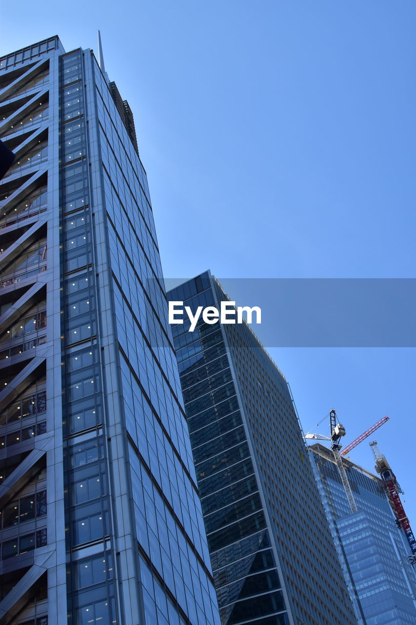 LOW ANGLE VIEW OF MODERN BUILDINGS AGAINST BLUE SKY