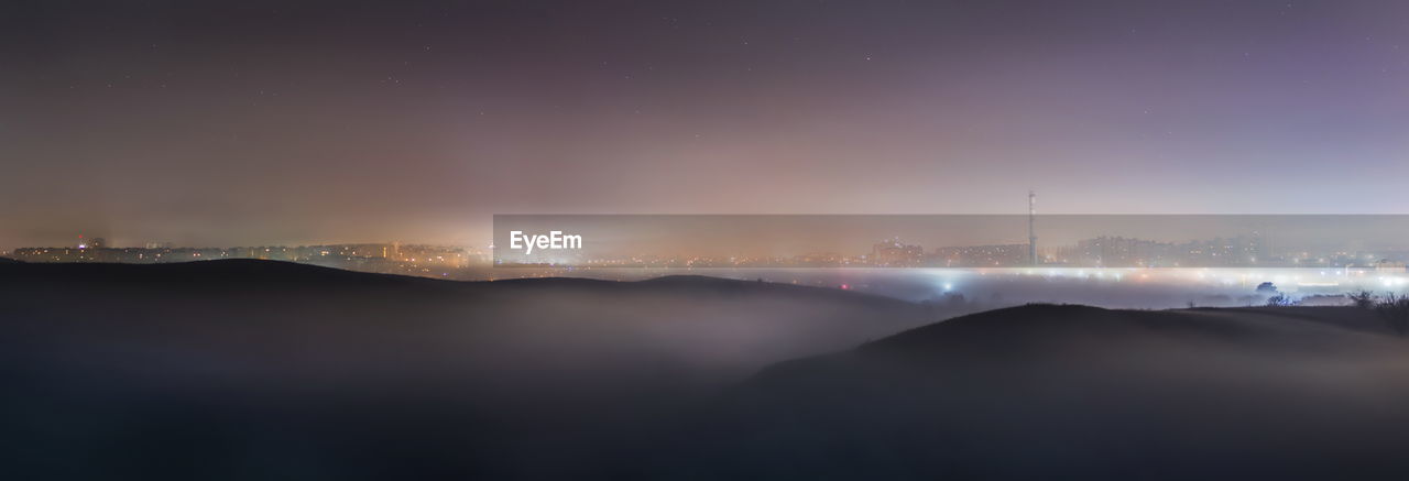 Illuminated cityscape against sky at night