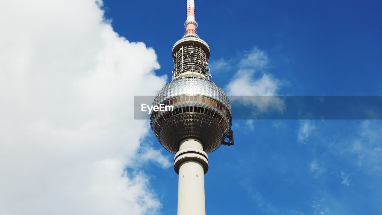 Low angle view of communications tower against blue sky during sunny day