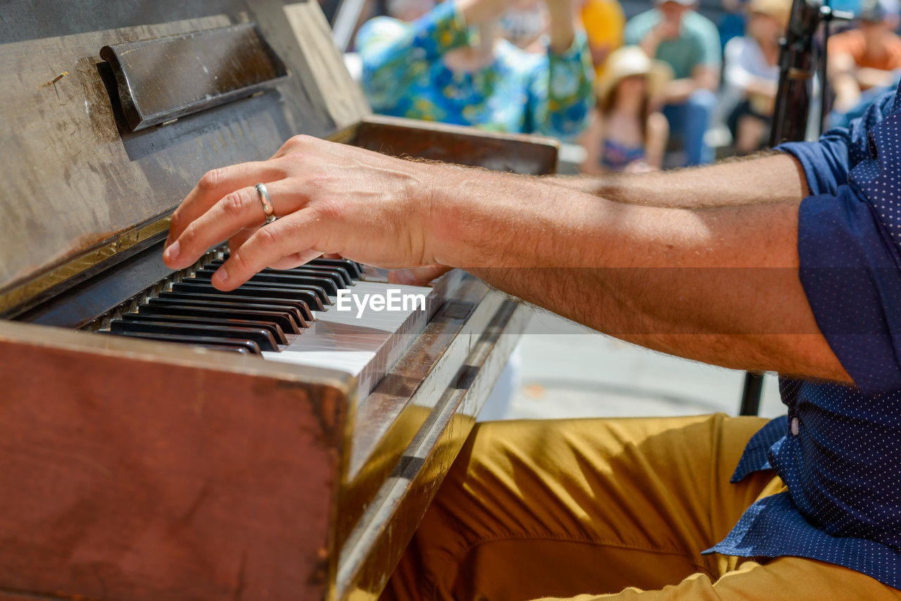 cropped hands of man playing piano