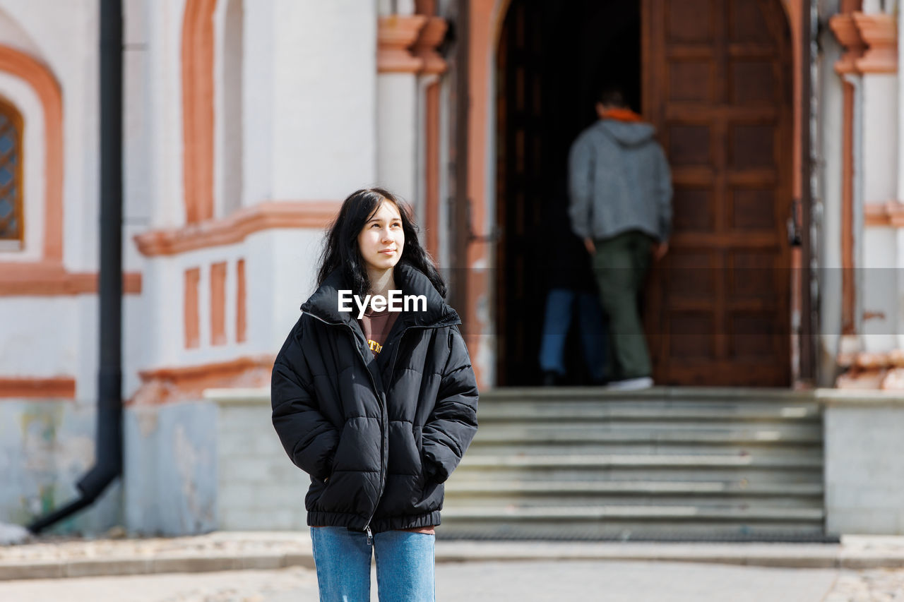 Girl standing against building