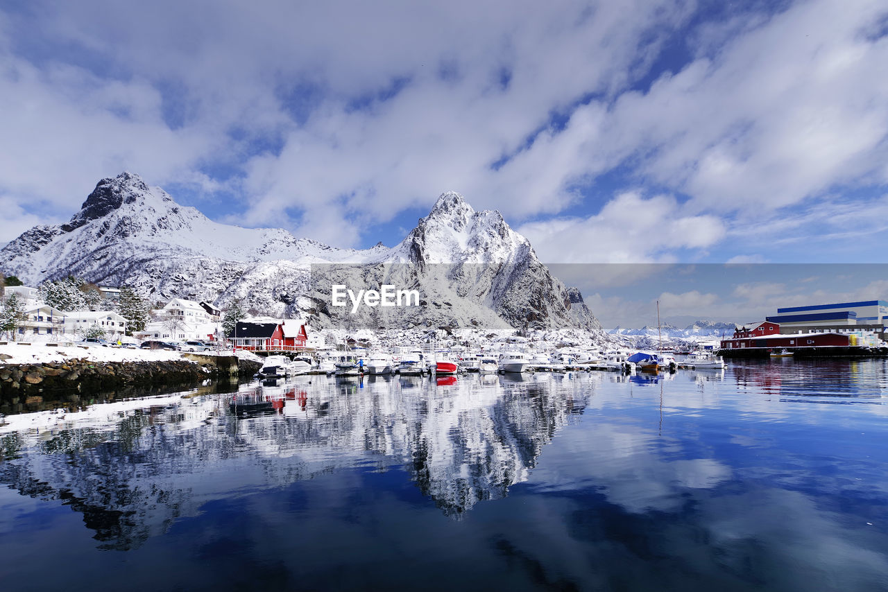 BUILT STRUCTURE BY SNOWCAPPED MOUNTAIN AGAINST SKY