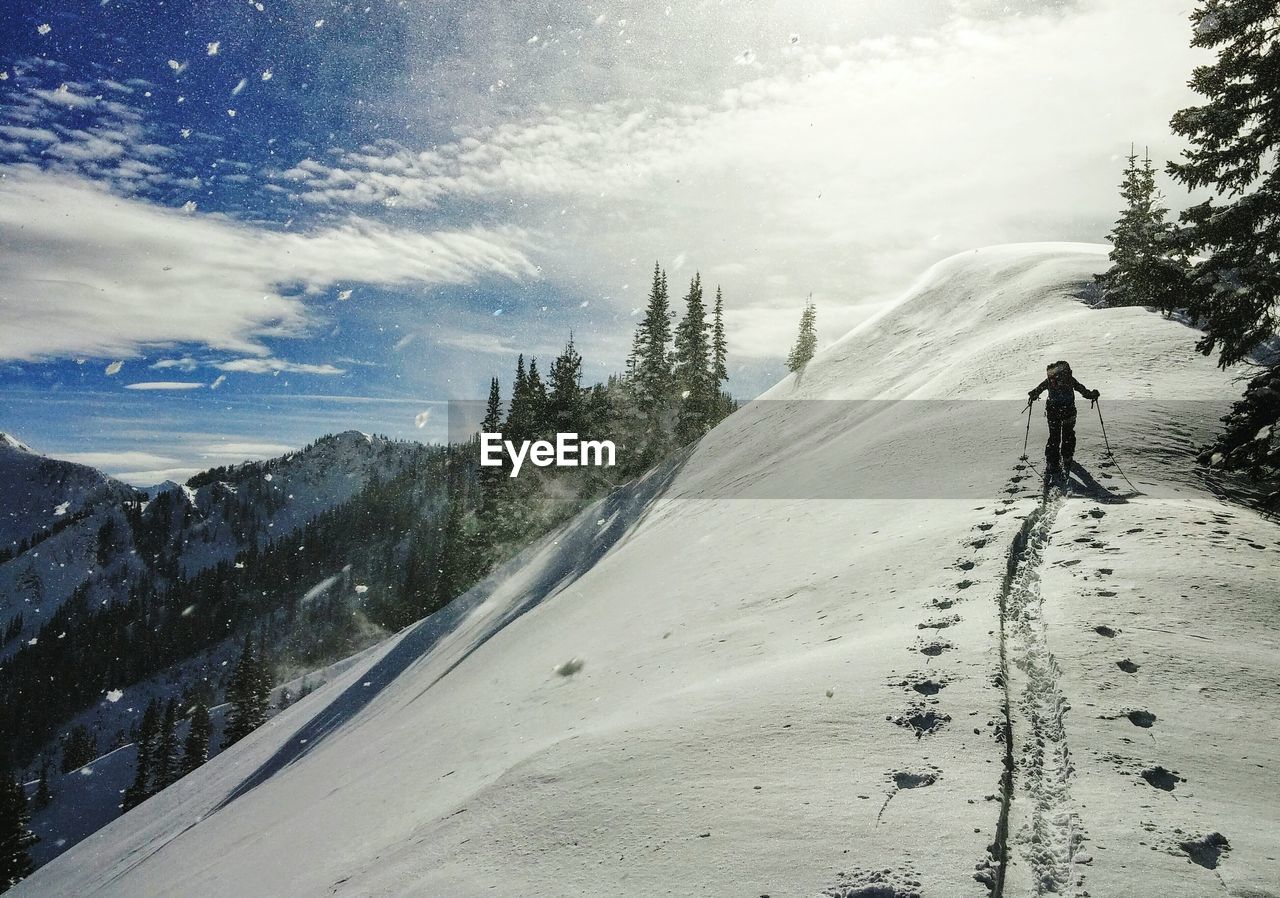 Silhouette person skiing on snowcapped mountain