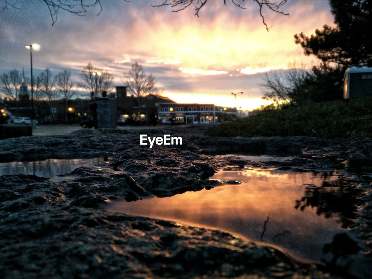 Puddle against sky during sunset