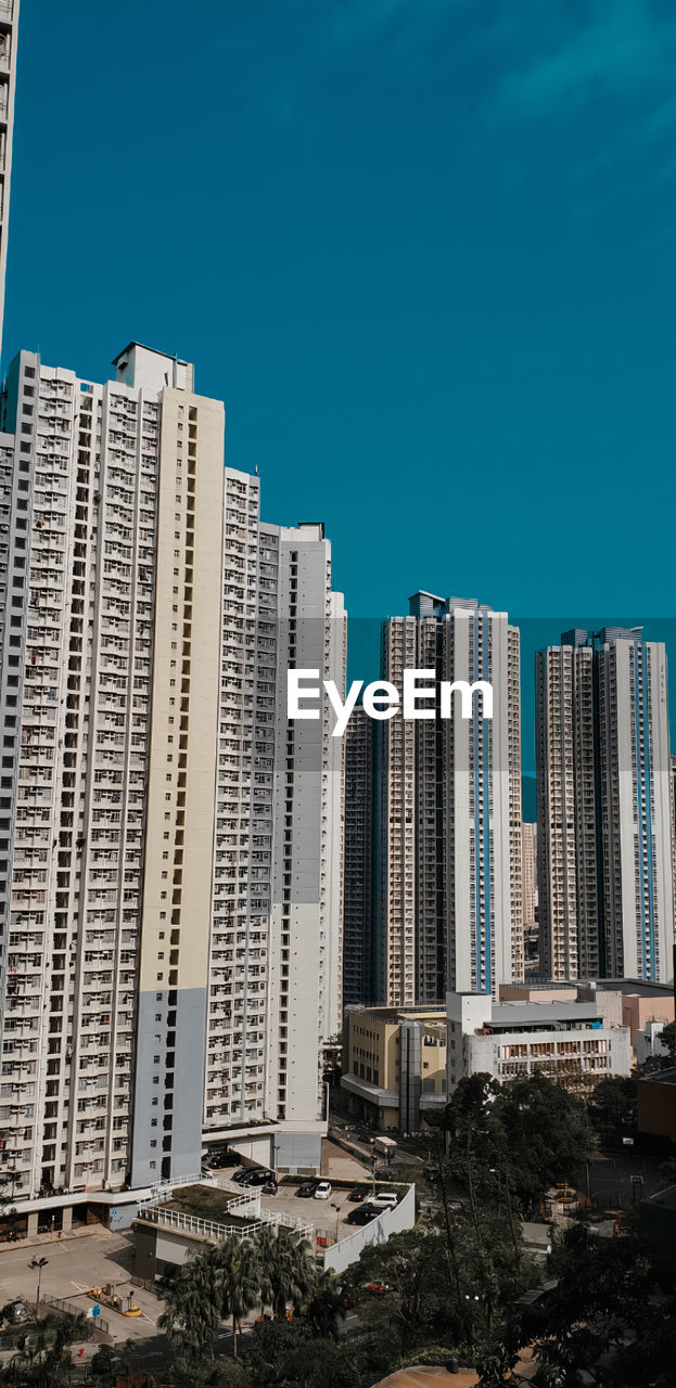 Modern buildings in city against clear blue sky