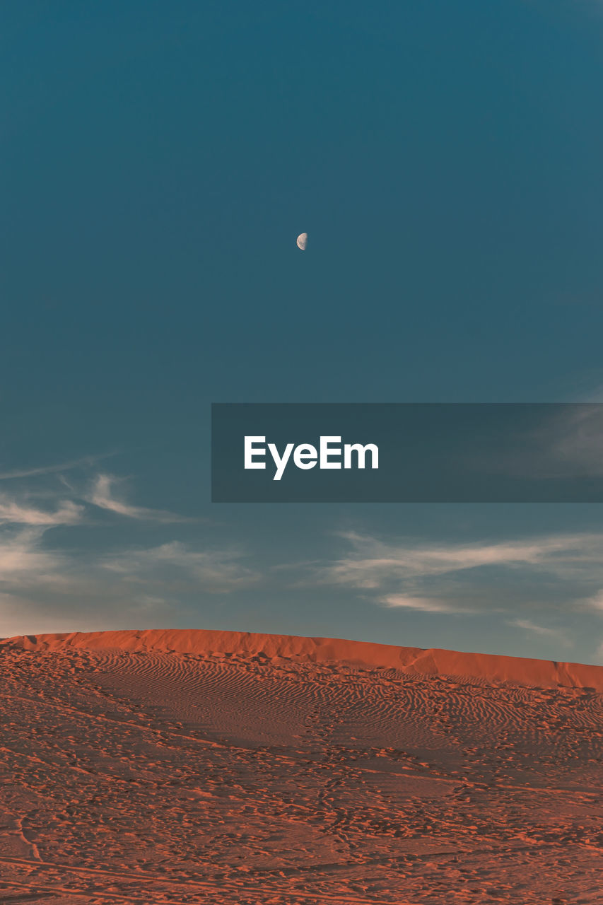 Scenic view of desert against sky and moon