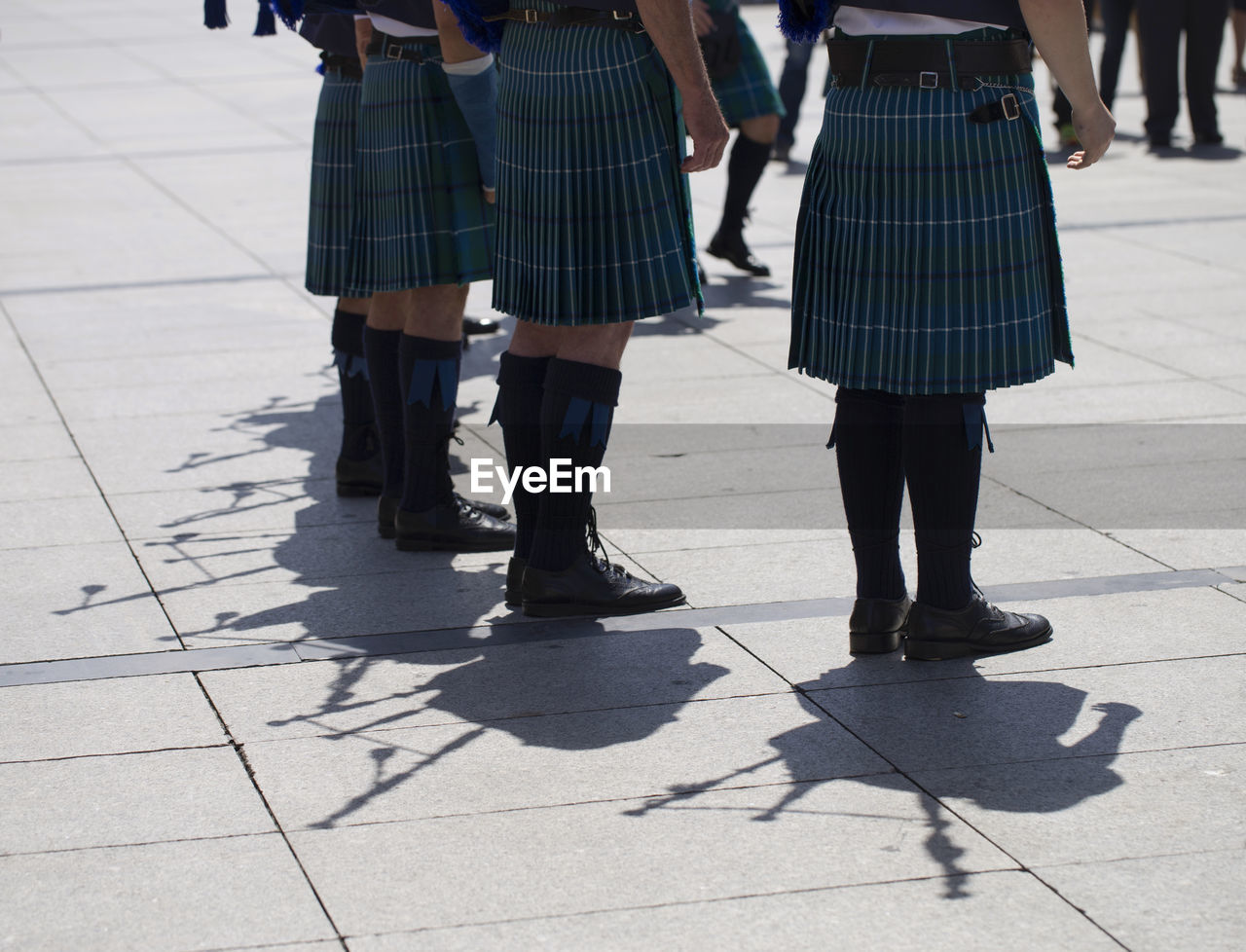 Low section of women standing on footpath