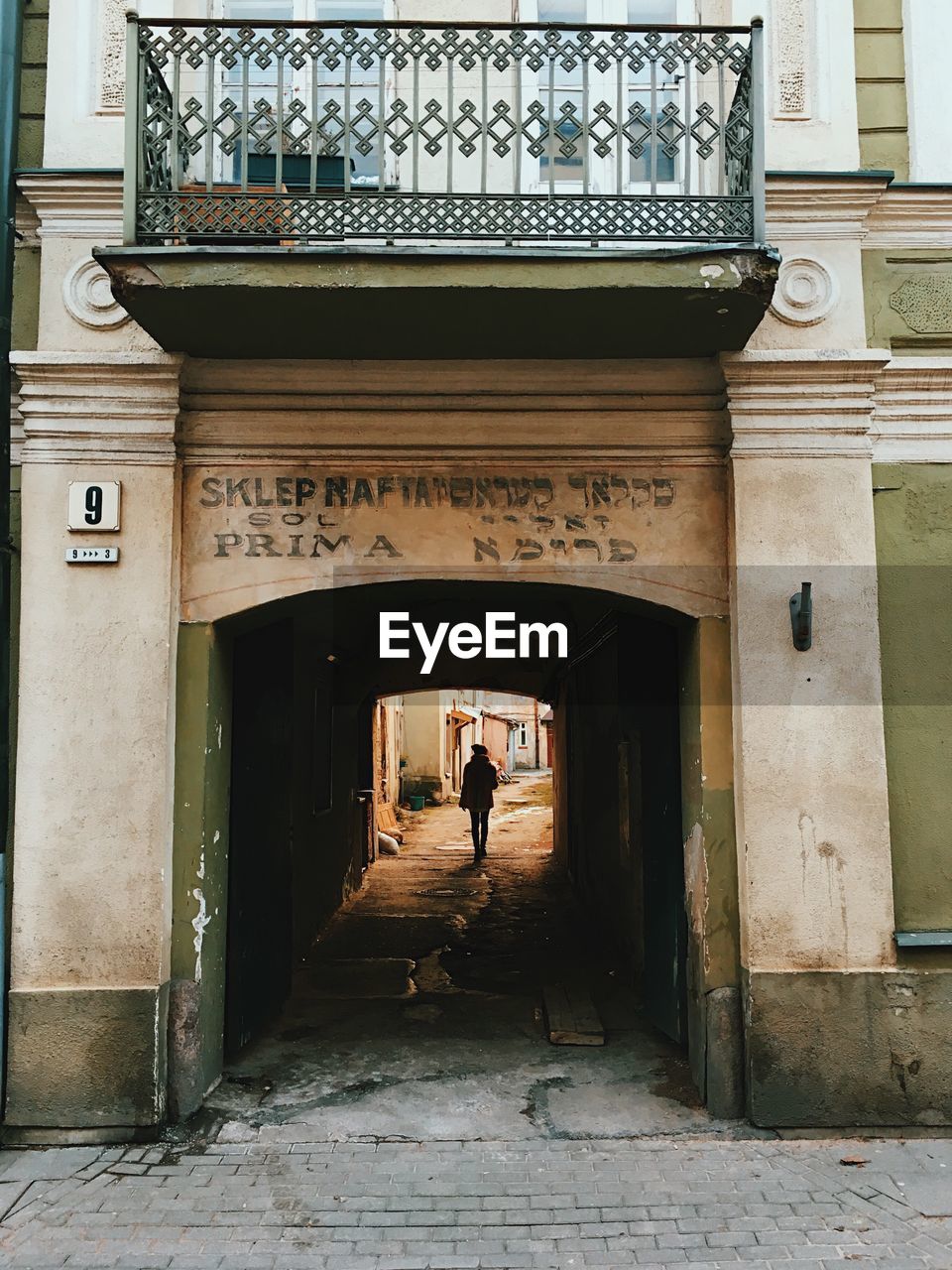 REAR VIEW OF WOMAN WALKING ON ENTRANCE