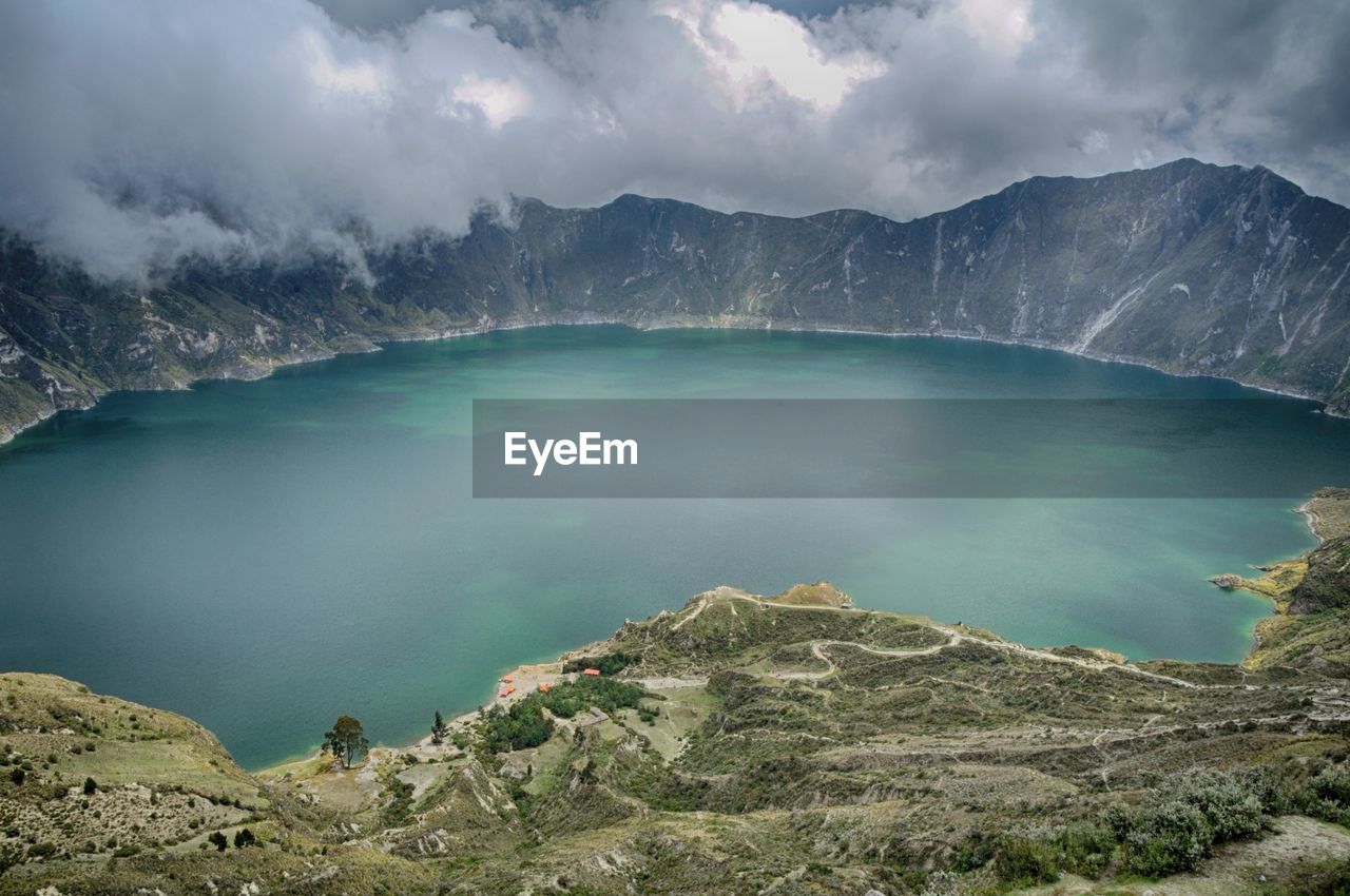 Scenic view of lake and mountains against cloudy sky