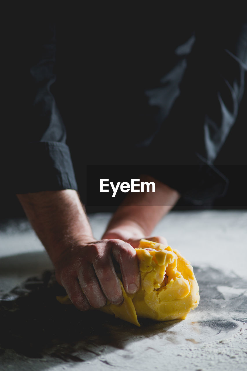 Close-up of chef's hands kneading dough