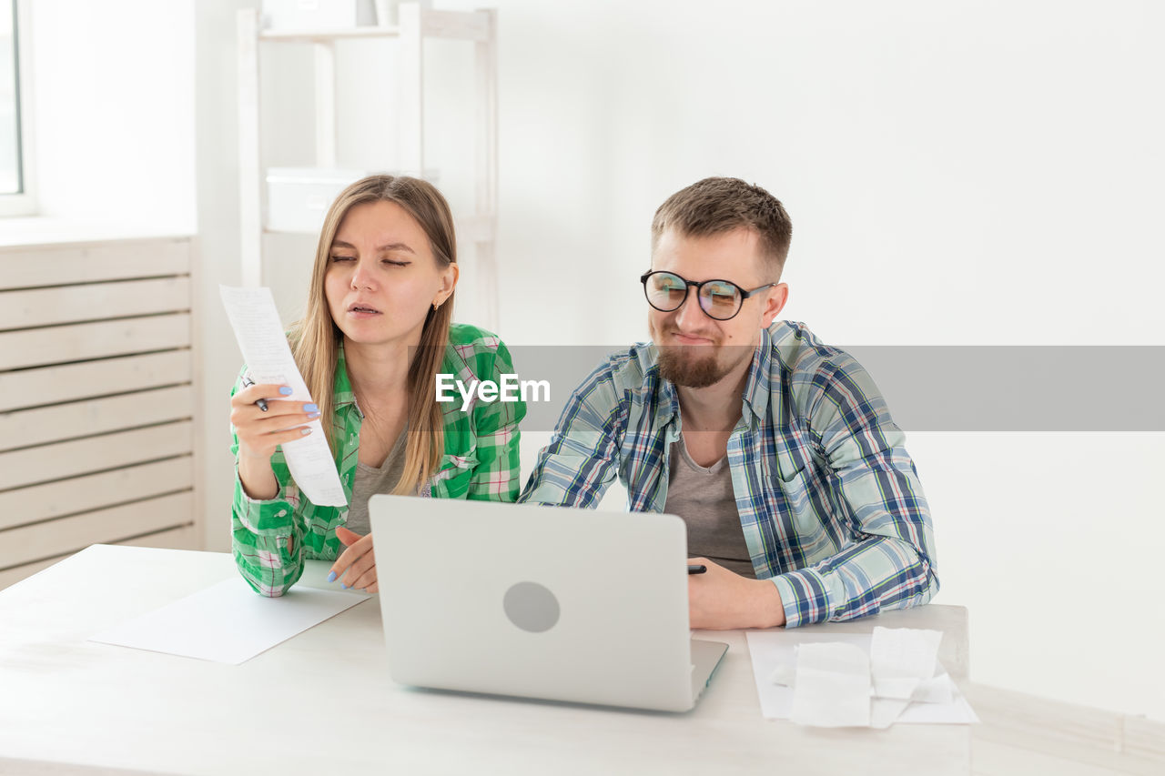 Young man using mobile phone while sitting on table