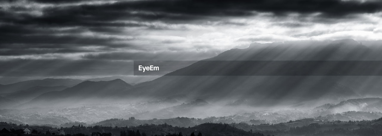 PANORAMIC VIEW OF MOUNTAINS AGAINST STORM CLOUDS